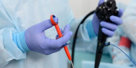 An urologist holding a urological surgical scope.