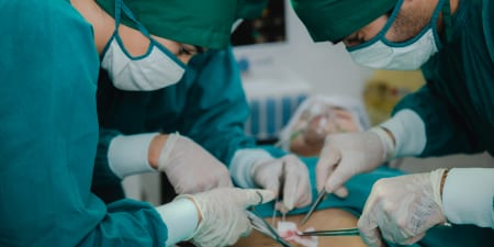 A team of urologists performing cystoscopy surgery.