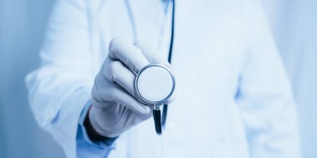 An urologist using stethoscope for physical examination.