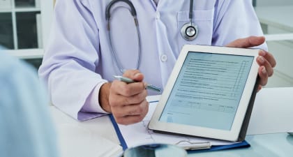 An urologist presenting the diagnosis report and medical history on a digital tablet.