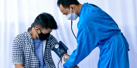 A health professional doing a physical examination for a male patient.