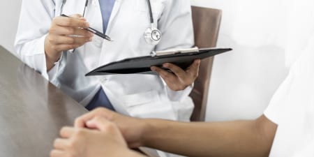 An urologist in discussion with a patient during physical examination.
