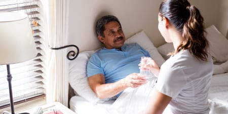 A health professional taking care of a patient under palliative care.