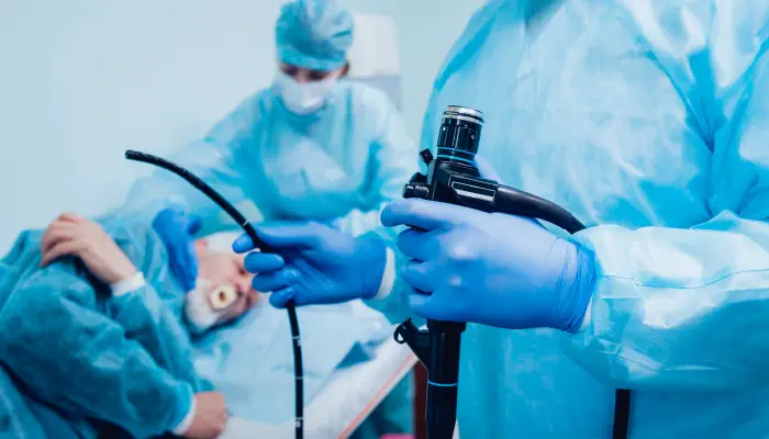 An urologist performing a cystoscopy for a patient in the operation theatre.
