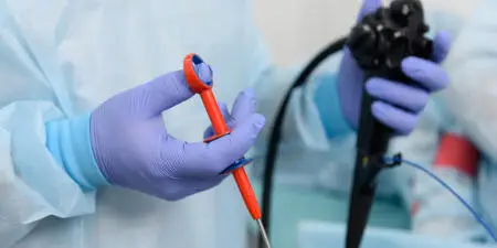 An urologist holding a urological surgical scope.