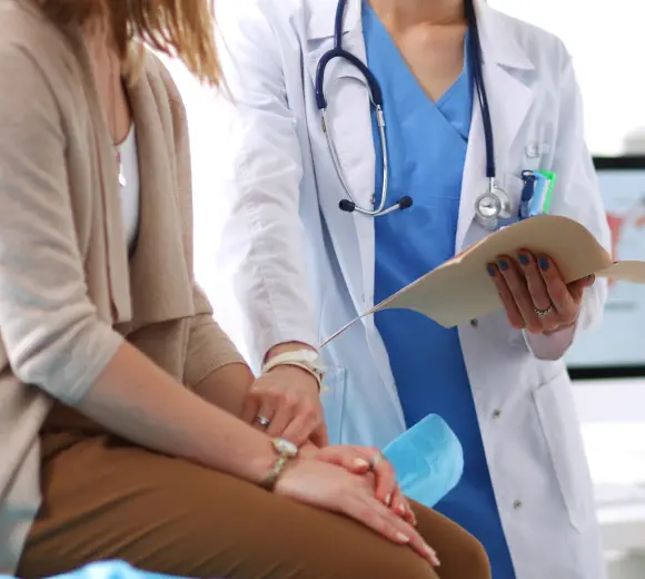 An urologist discusses incontinence treatments with a patient.