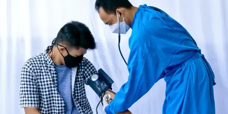 A health professional doing a physical examination for a male patient.