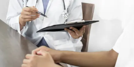 An urologist in discussion with a patient during physical examination.
